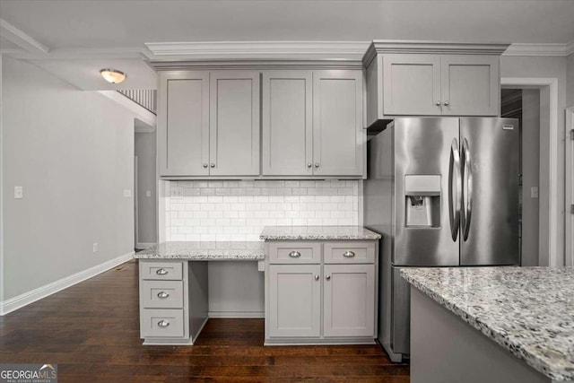 kitchen featuring gray cabinetry, stainless steel fridge, light stone countertops, and decorative backsplash