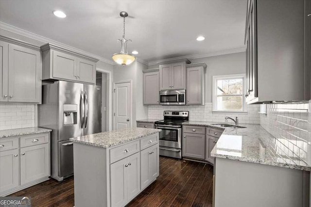 kitchen featuring backsplash, ornamental molding, stainless steel appliances, pendant lighting, and a center island