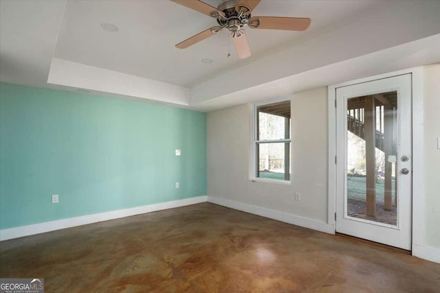 unfurnished room with a raised ceiling and ceiling fan