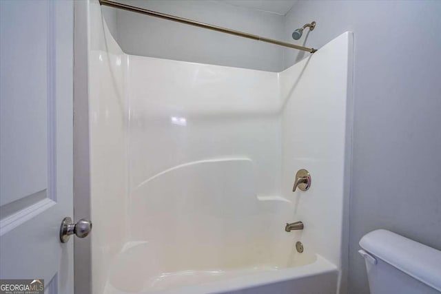 bathroom featuring toilet and bathing tub / shower combination