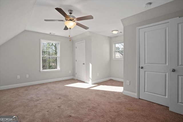 additional living space featuring light carpet, ceiling fan, and lofted ceiling