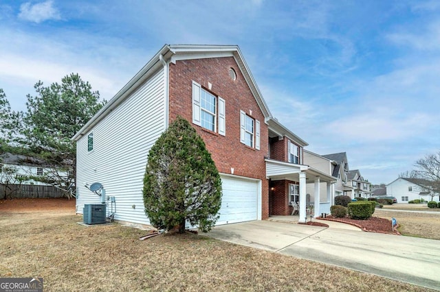 view of front facade featuring a front lawn, central AC unit, and a garage