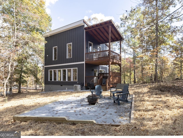 back of house featuring an outdoor fire pit and a wooden deck