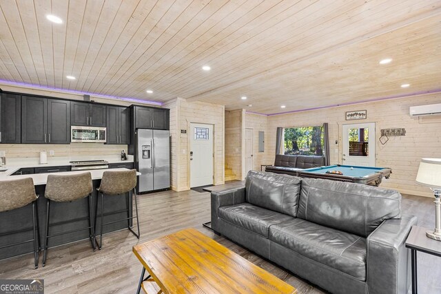 living room featuring wooden walls, wooden ceiling, light wood-type flooring, and pool table