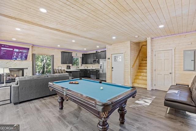 game room with wood walls, light hardwood / wood-style flooring, wooden ceiling, and pool table