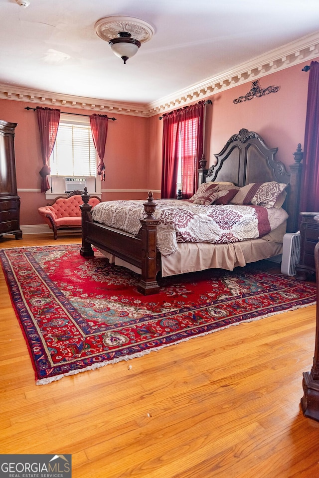 bedroom with wood-type flooring and crown molding