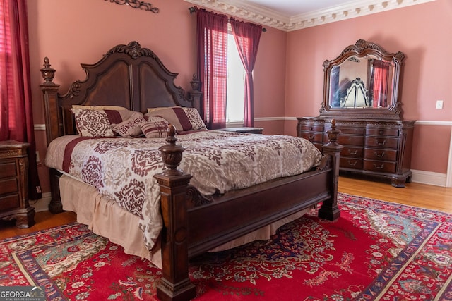 bedroom with crown molding and light hardwood / wood-style floors