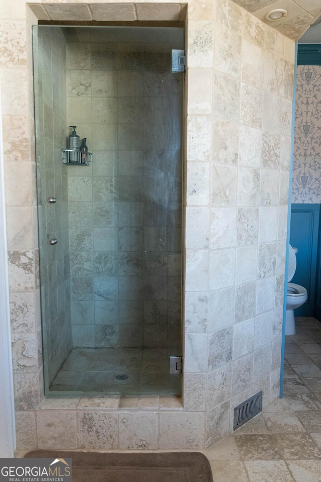 bathroom with toilet and tiled shower