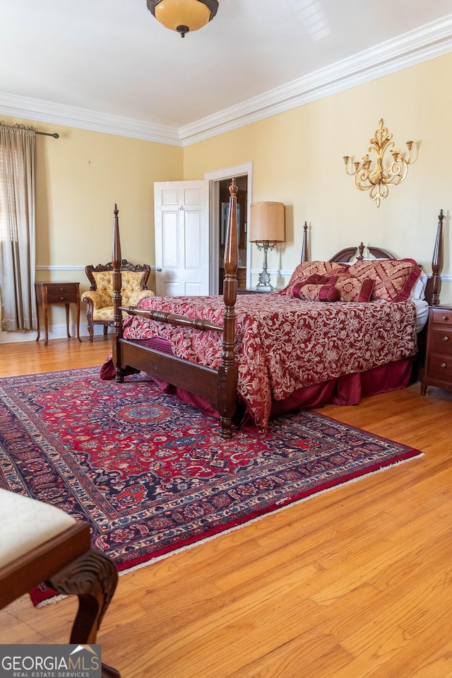 bedroom with hardwood / wood-style flooring and crown molding