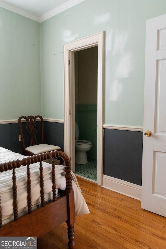 bedroom featuring ensuite bath, crown molding, and light hardwood / wood-style flooring