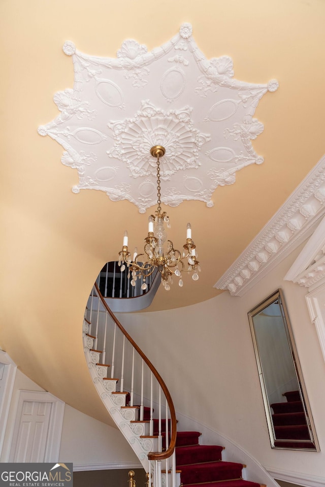 stairway with a high ceiling and an inviting chandelier