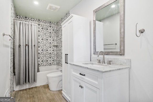 full bathroom with vanity, toilet, hardwood / wood-style floors, and shower / bath combo