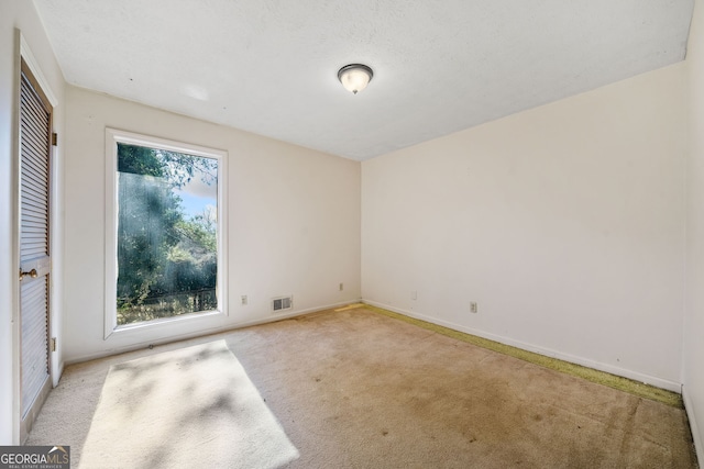 spare room featuring light colored carpet