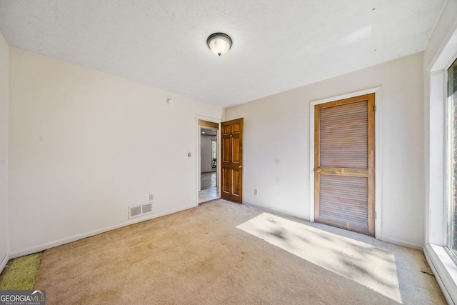 carpeted spare room featuring a textured ceiling