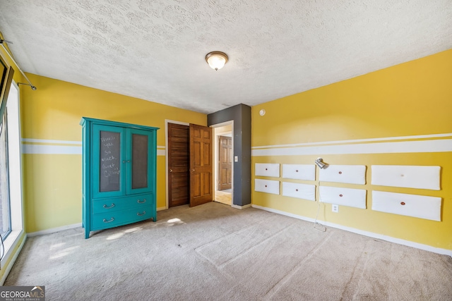 unfurnished bedroom with carpet floors, a closet, and a textured ceiling