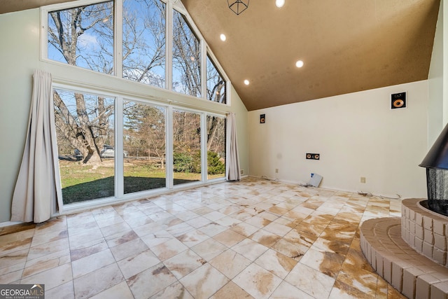 unfurnished living room featuring high vaulted ceiling