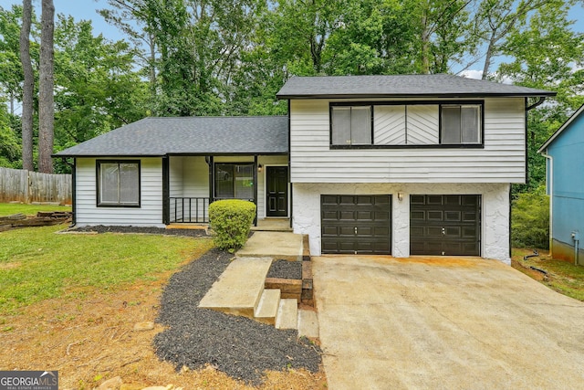 tri-level home with a front yard, a garage, and a porch