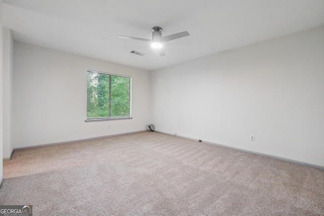 carpeted spare room featuring ceiling fan