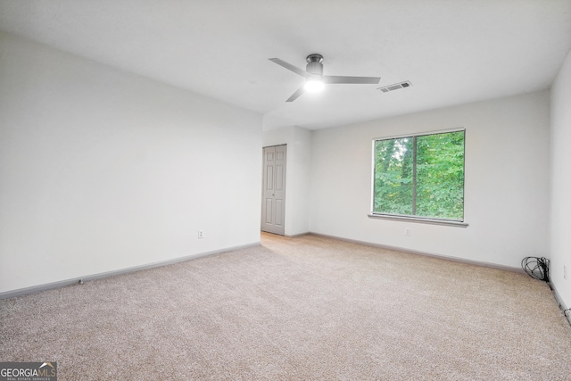 carpeted spare room with ceiling fan