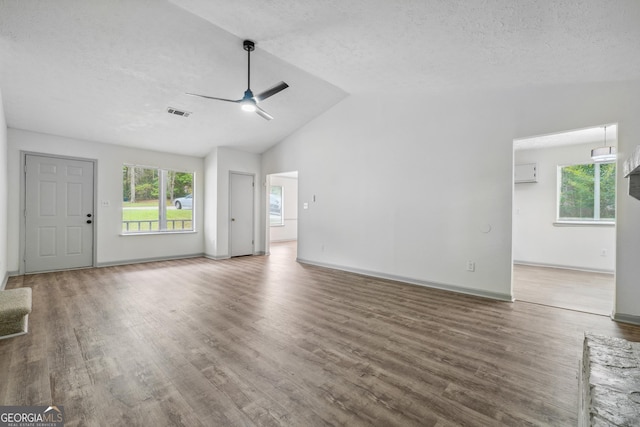 unfurnished living room featuring ceiling fan, dark wood-type flooring, a textured ceiling, and lofted ceiling