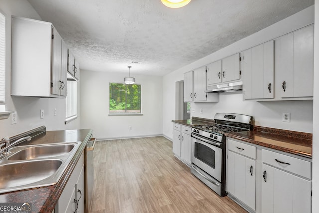 kitchen featuring pendant lighting, appliances with stainless steel finishes, white cabinetry, sink, and light wood-type flooring