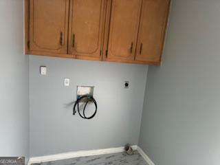 washroom with hookup for an electric dryer, hookup for a washing machine, and cabinets