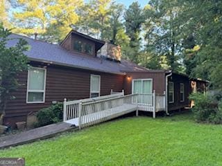 back of house featuring a yard and a wooden deck