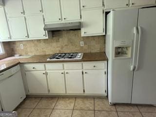 kitchen featuring light tile patterned floors, white appliances, and white cabinetry