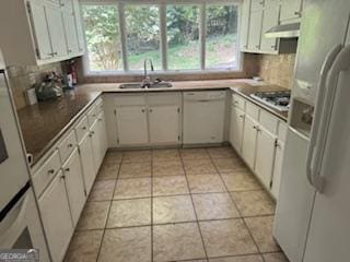 kitchen featuring light tile patterned floors, white cabinets, white appliances, and sink