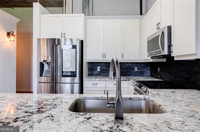 kitchen with sink, white cabinetry, and stainless steel appliances