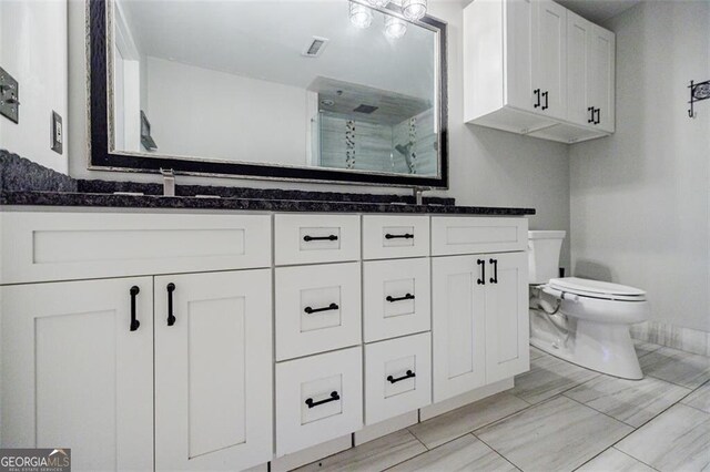 bathroom with vanity, toilet, and a shower with shower door