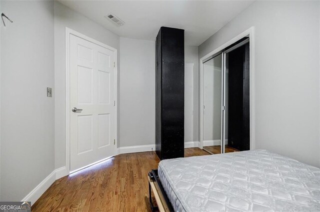 bedroom with wood-type flooring and a closet