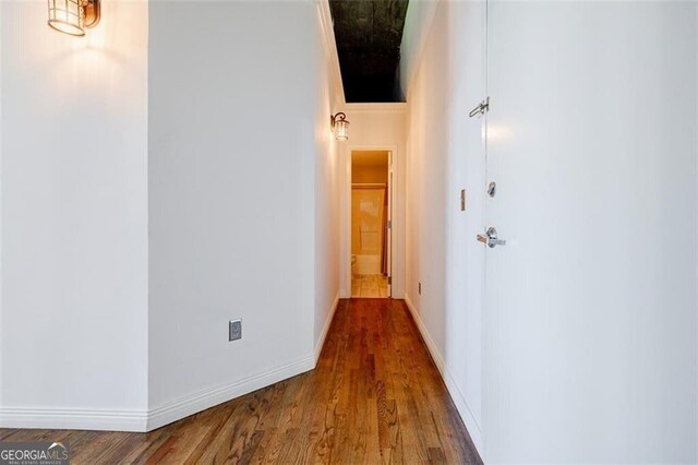 corridor with hardwood / wood-style flooring