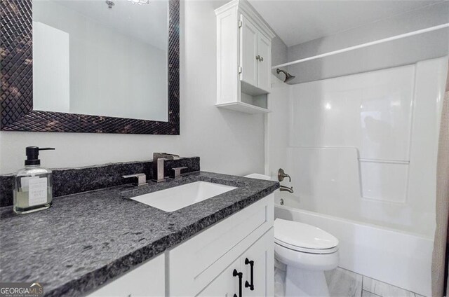 full bathroom featuring washtub / shower combination, vanity, and toilet