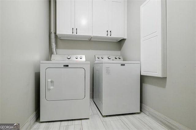 washroom with washer and clothes dryer and cabinets