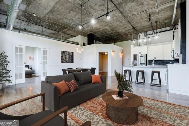 living room featuring french doors and a towering ceiling