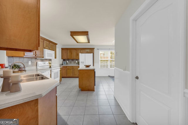 kitchen with light tile patterned floors, white appliances, tasteful backsplash, and sink