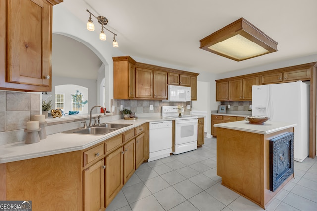 kitchen featuring a kitchen island, white appliances, sink, and tasteful backsplash