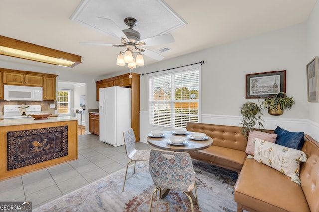 tiled dining space with ceiling fan