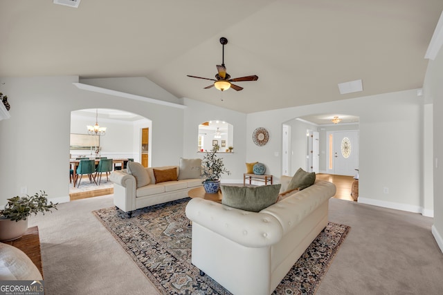 living room with light carpet, ceiling fan with notable chandelier, vaulted ceiling, and ornamental molding