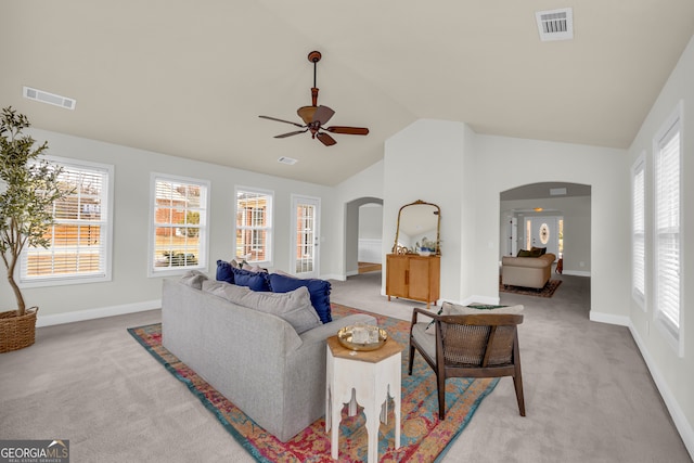 living room featuring ceiling fan, plenty of natural light, high vaulted ceiling, and light colored carpet