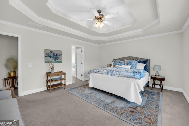 carpeted bedroom featuring a raised ceiling, ensuite bath, ceiling fan, and ornamental molding