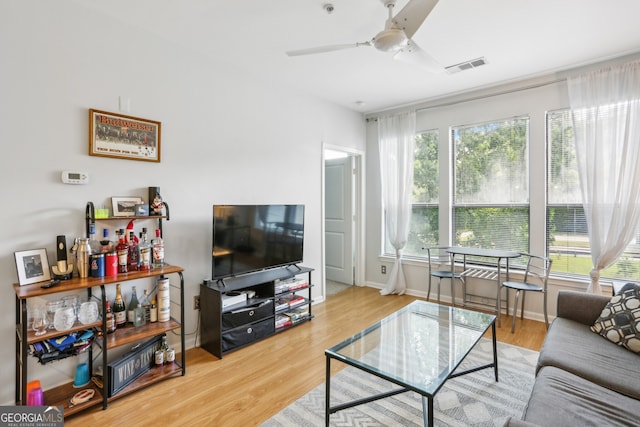 living room featuring ceiling fan, hardwood / wood-style floors, and plenty of natural light