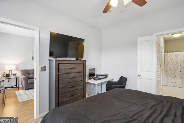 bedroom with ceiling fan, light hardwood / wood-style floors, and ensuite bath