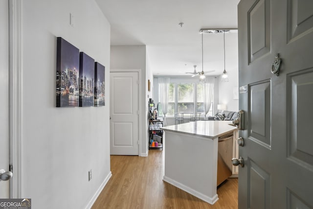 kitchen featuring kitchen peninsula, ceiling fan, dishwasher, and light wood-type flooring