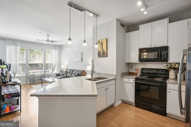 kitchen with kitchen peninsula, sink, white cabinetry, and black appliances