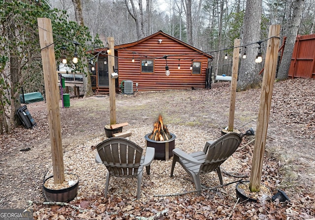 view of yard with an outdoor fire pit and central air condition unit