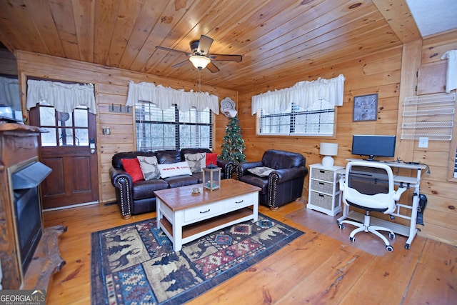 home office featuring wood-type flooring, ceiling fan, and wood walls