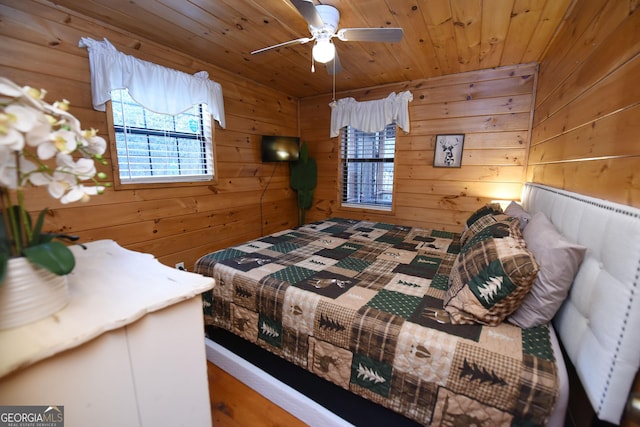 bedroom with wood walls, ceiling fan, and wood ceiling