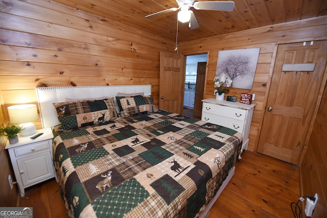 bedroom with dark hardwood / wood-style flooring, ceiling fan, wood walls, and wood ceiling